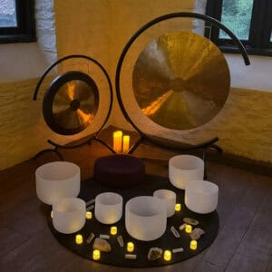 Gong meditation space with crystal bowls and candle lighting for relaxation and healing at The Goddess Haven UK.