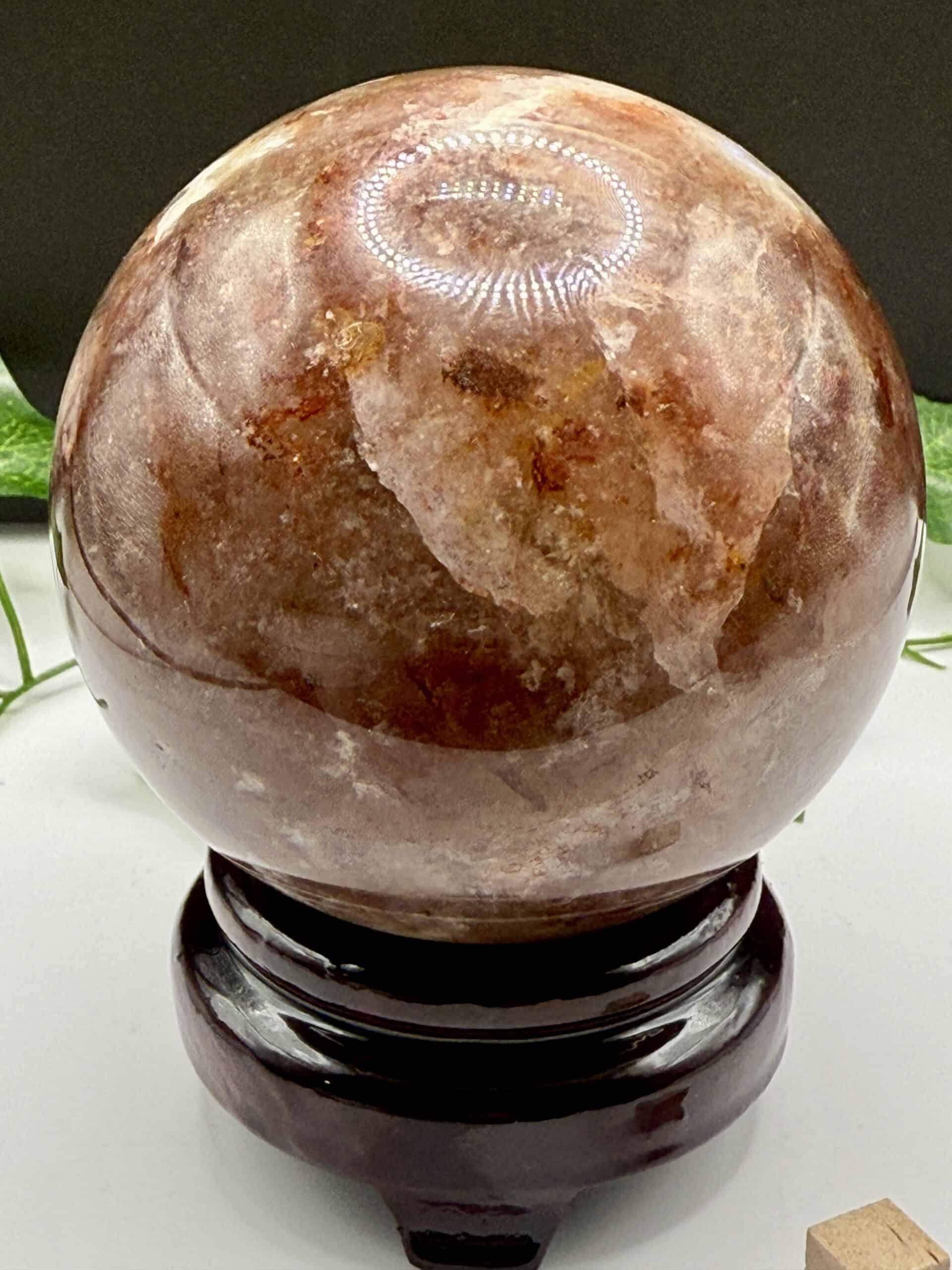 Polished brown Himalayan salt lamp on a black stand, emitting a warm glow, ideal for home decor, relaxation, and spiritual wellness.