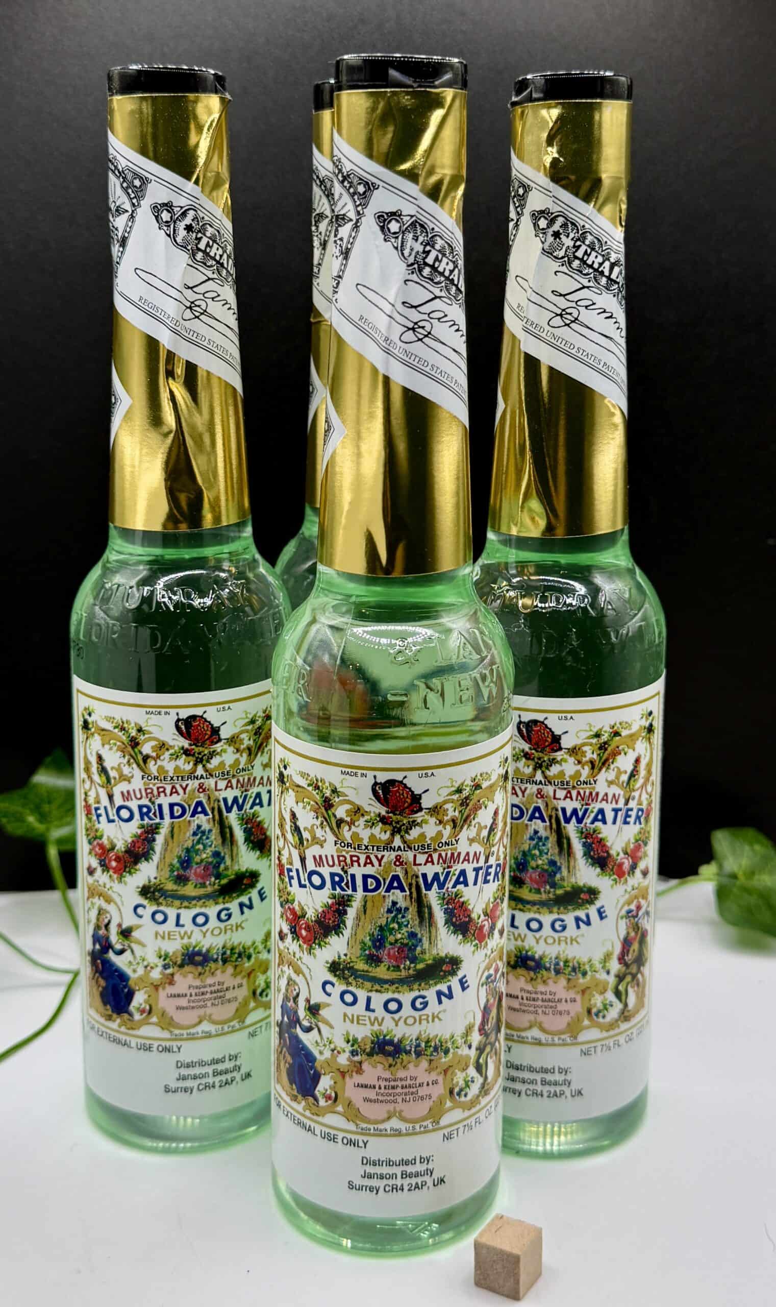 Three bottles of Florida Water cologne with ornate labels and gold caps, used for spiritual cleansing and rituals.