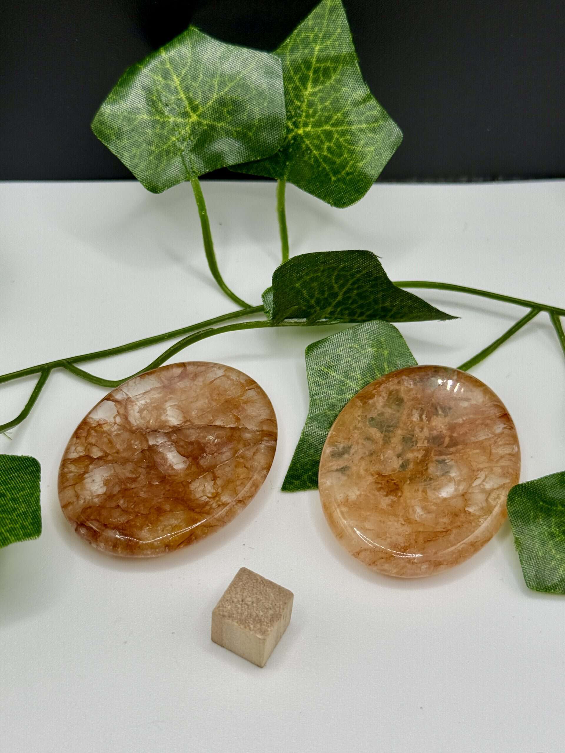 Rose Quartz healing crystal with polished, smooth surface, accompanied by vibrant green ivy leaves for natural healing and positive energy.