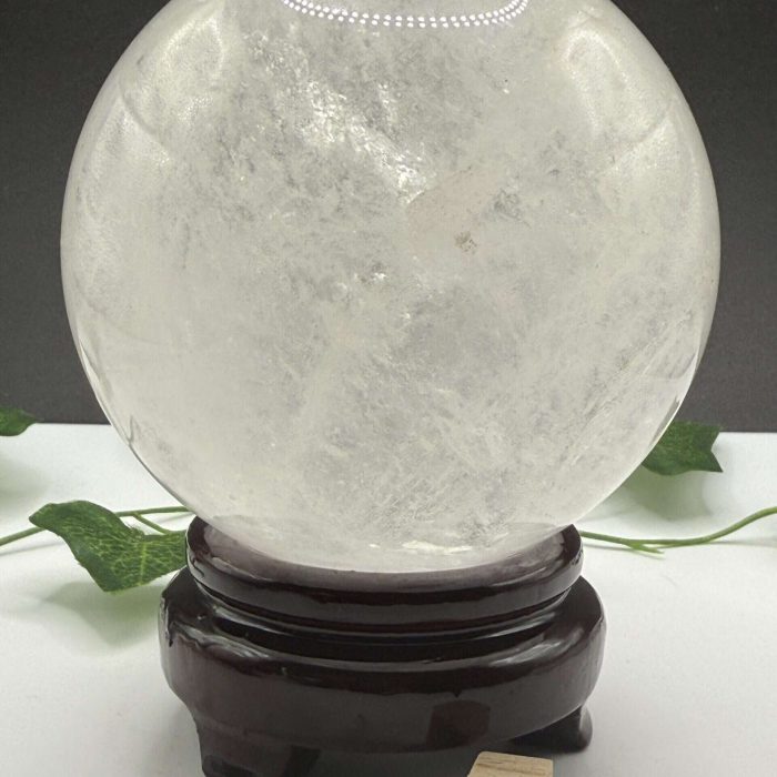 Lunar crystal ball resting on a dark wooden stand, illuminated with LED lights, symbolizing lunar energy and spiritual healing, perfect for meditation or holistic practices.