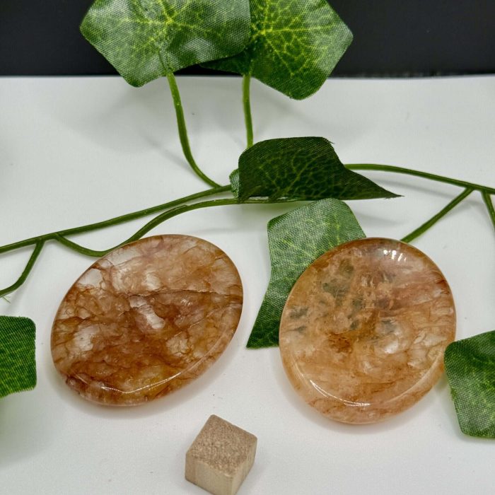 Rose Quartz healing crystal with polished, smooth surface, accompanied by vibrant green ivy leaves for natural healing and positive energy.